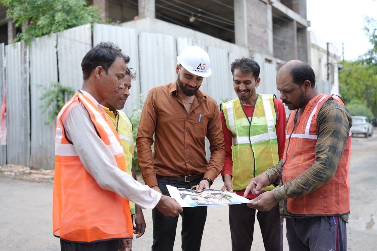 AS Infratech project manager reviewing plans with team on site